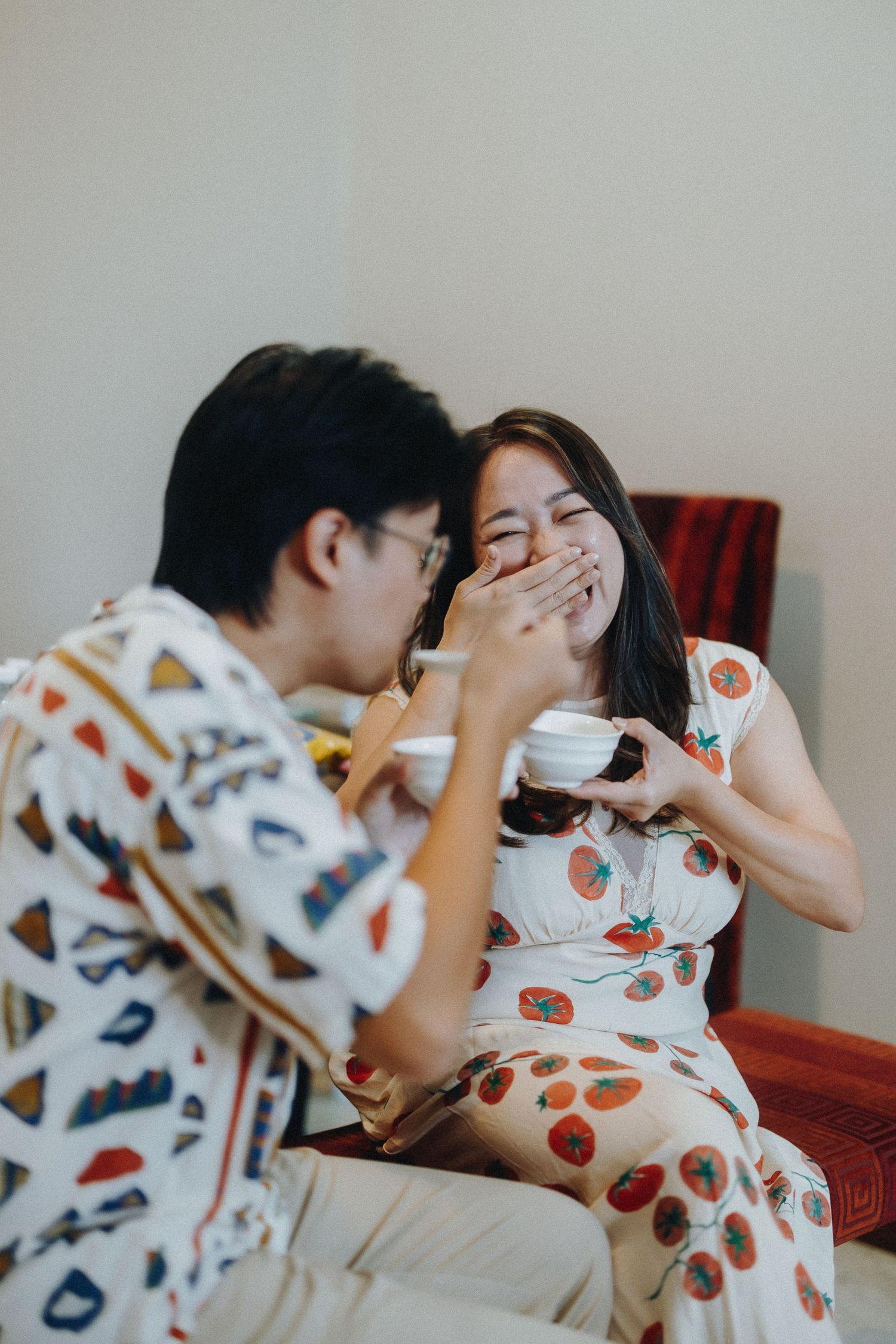 Sequence of tender moments between couple in matching patterned pajamas showing playful affection while lying down.