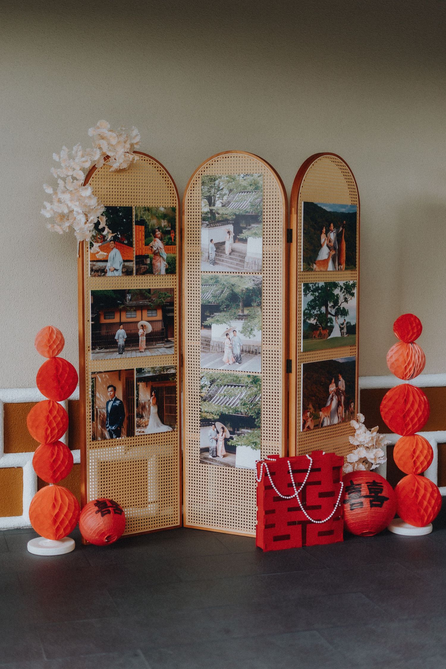 Vintage rattan room divider decorated with photos, red paper lanterns and festive decorations.
