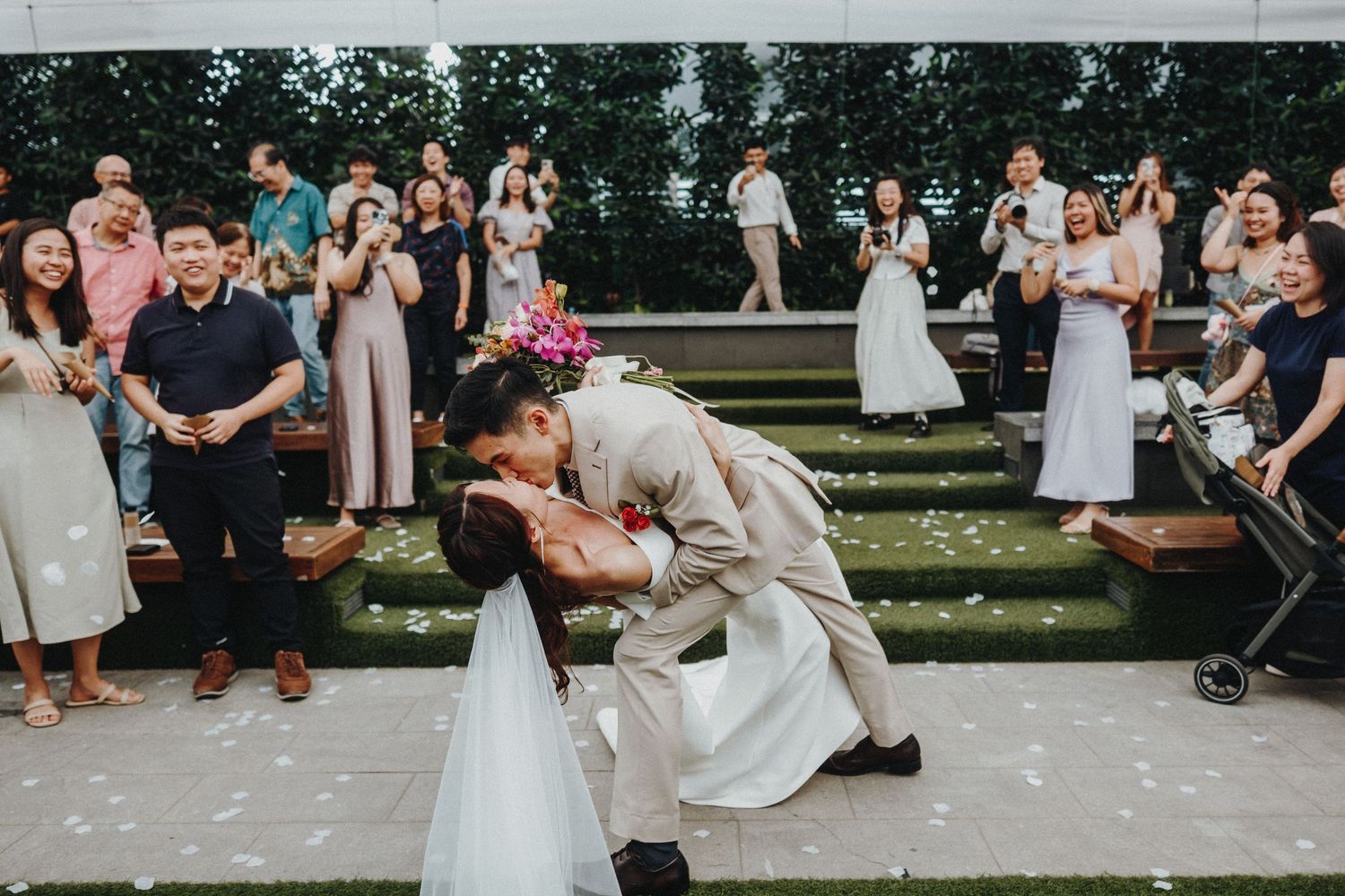 A romantic moment during an outdoor wedding ceremony as guests look on with joy.