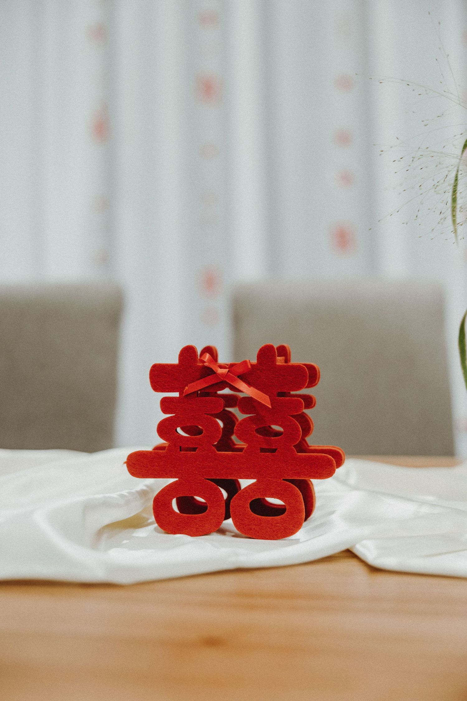 Red double happiness Chinese wedding symbols displayed on a white surface against a blurred background.