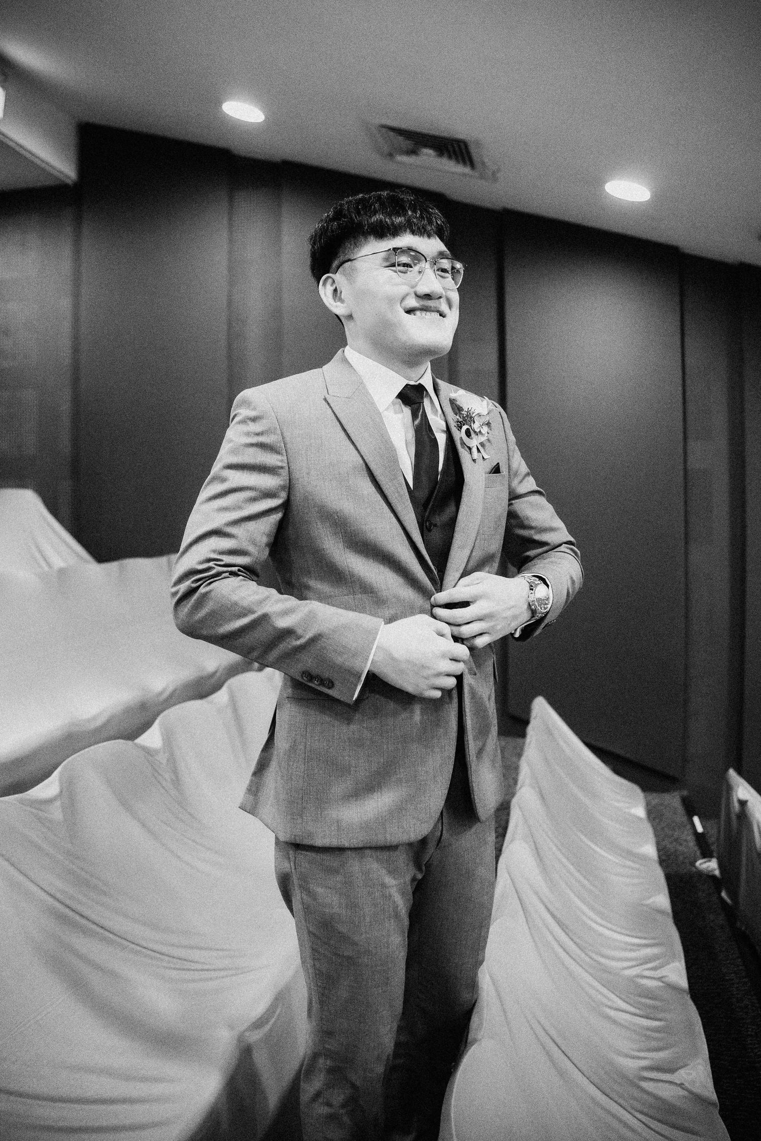 A sequence of black and white photos showing a groom getting ready in formal attire.