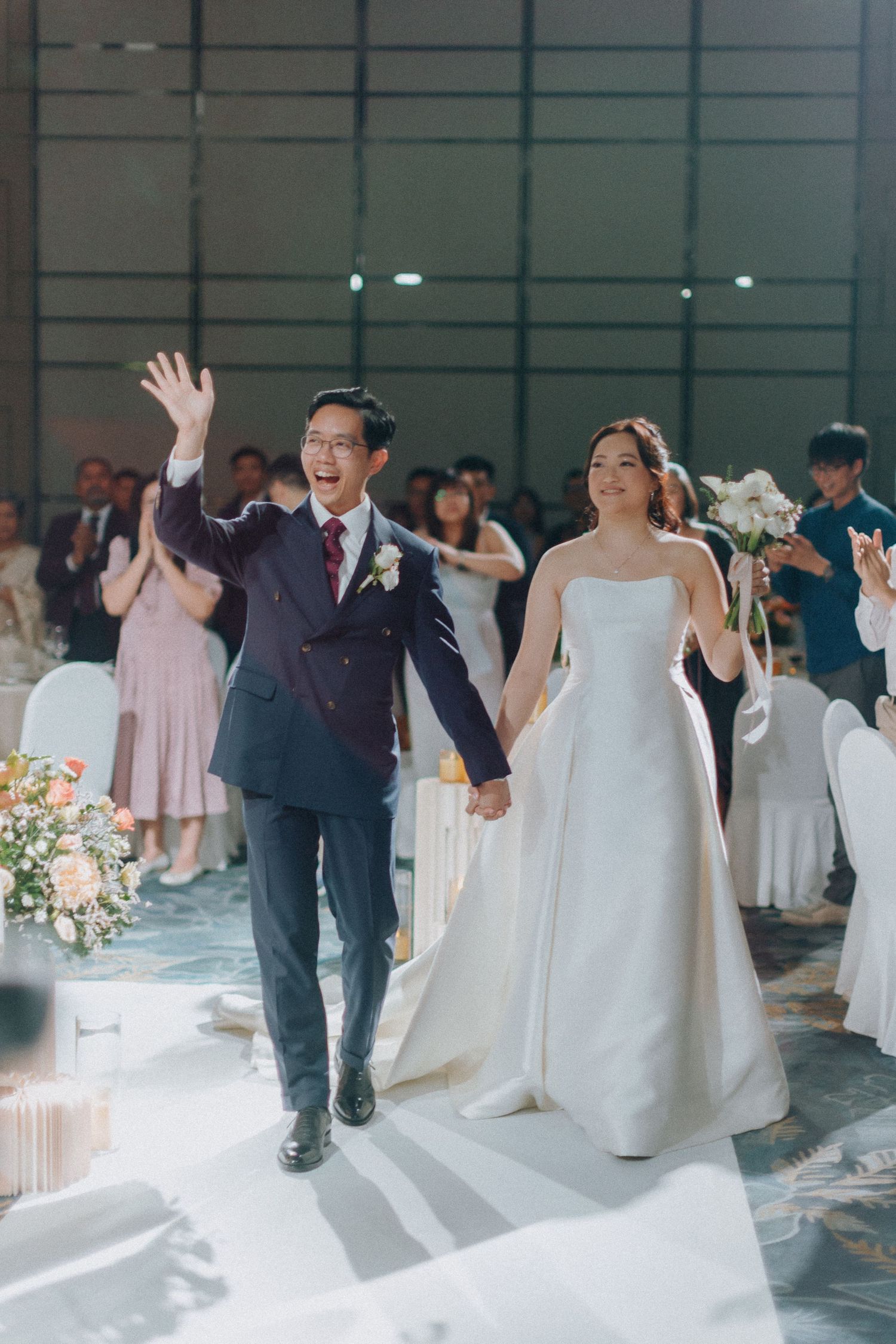 Wedding reception celebration in an elegant ballroom with guests in formal attire.