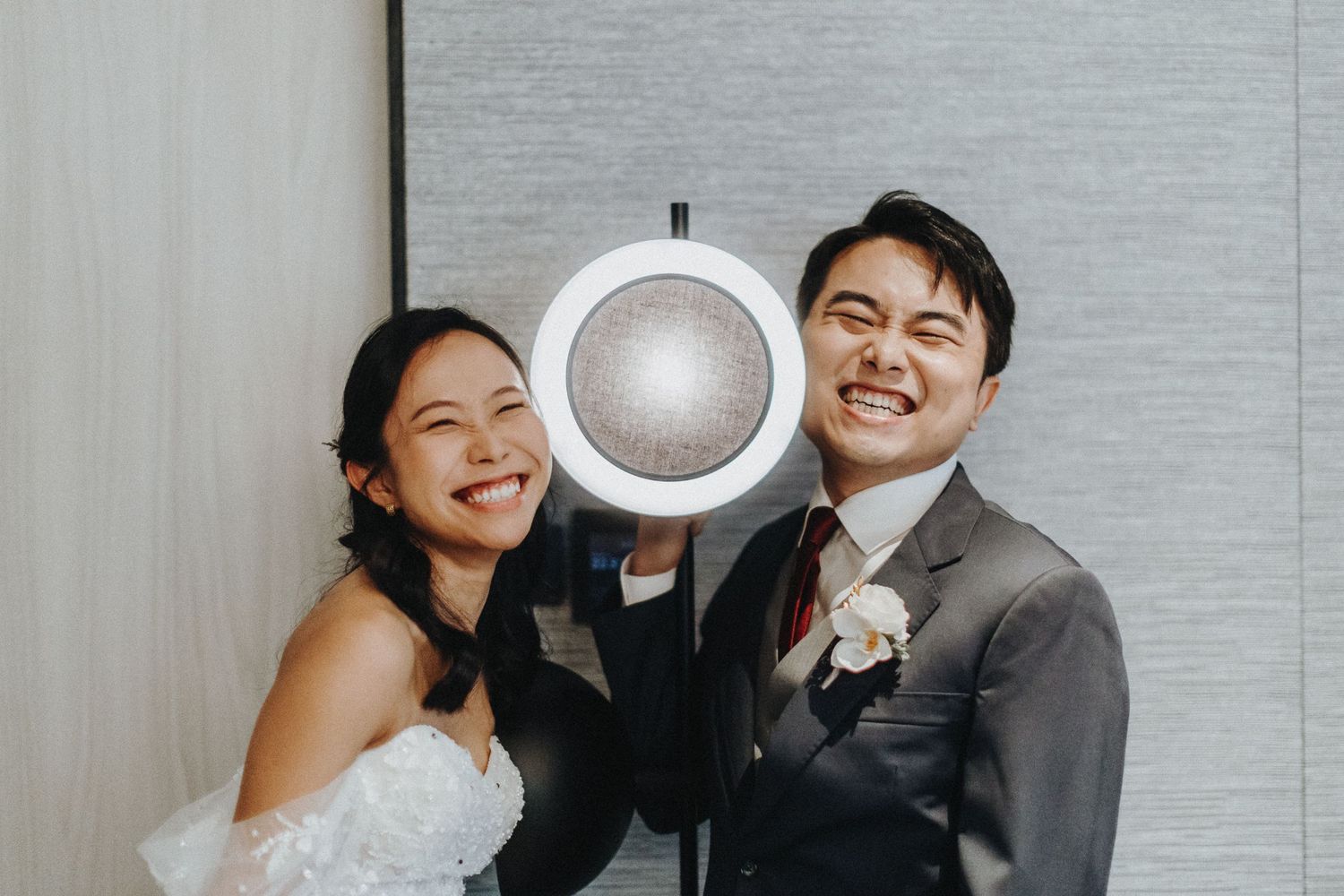 A playful wedding photo with a large coffee cup prop in a modern setting.