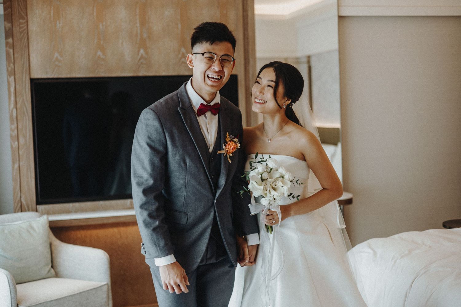Intimate wedding photographs being taken in an elegantly furnished hotel suite.
