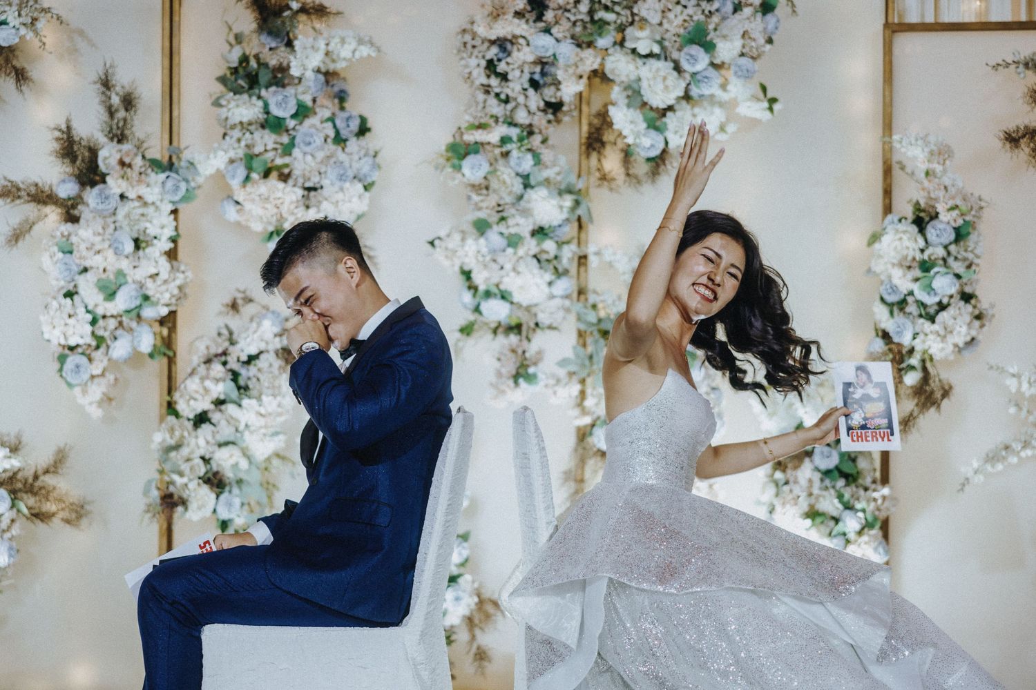 Wedding celebration with floral wall decorations and elegant white and blue color scheme.