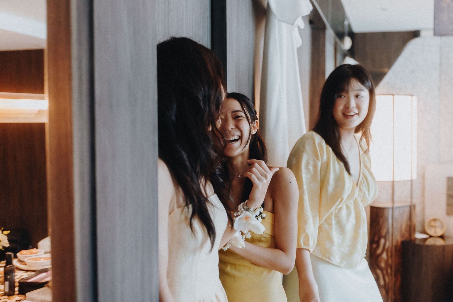 Guests in formal attire gather and mingle at an indoor wedding celebration.