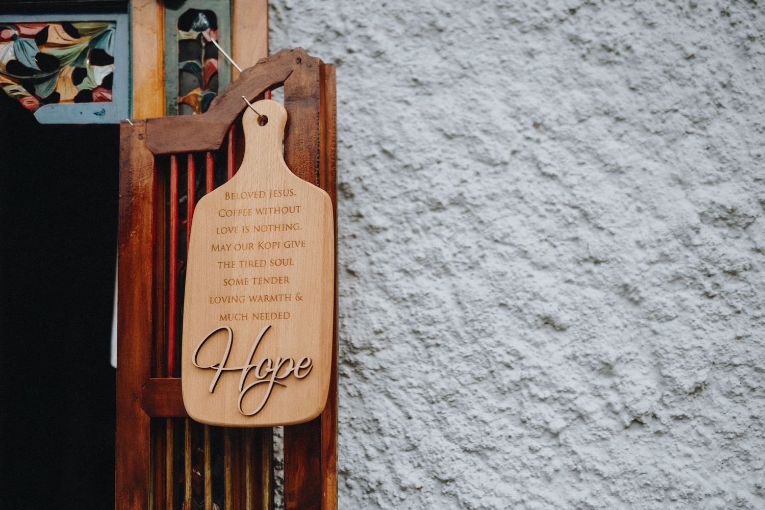 Wooden wall decorations and signs mounted on a textured white surface.