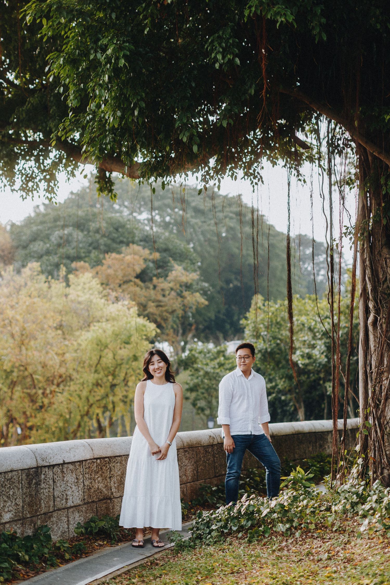 A romantic photoshoot in a lush garden setting with hanging vines and natural greenery.