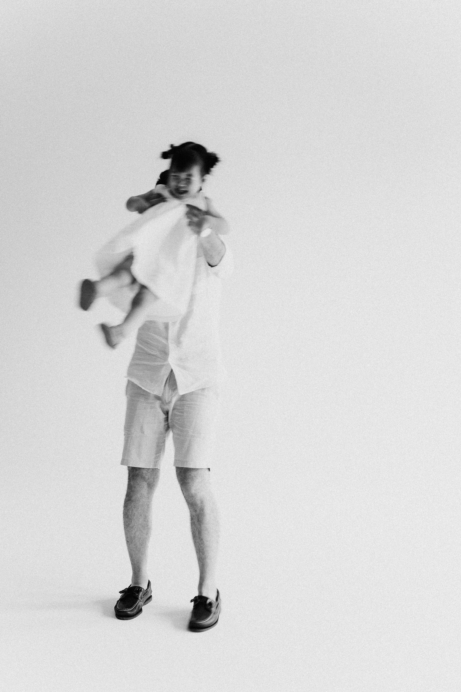 A playful sequence showing movement and dance in white clothing against a light backdrop.