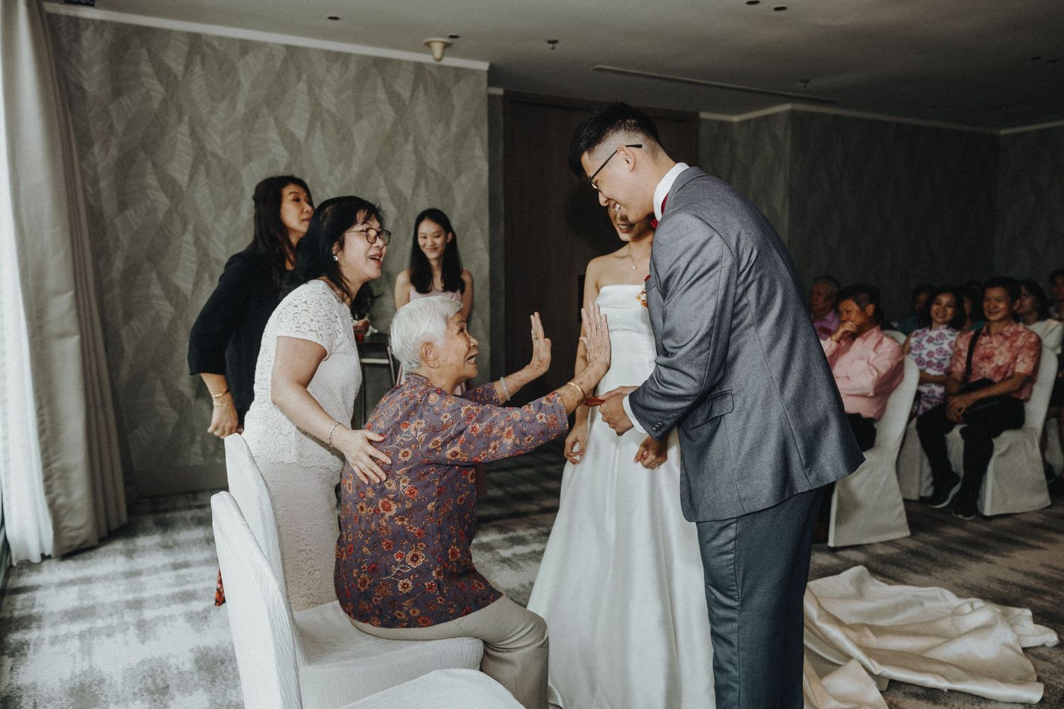 Wedding celebration with guests in a dimly lit reception venue.