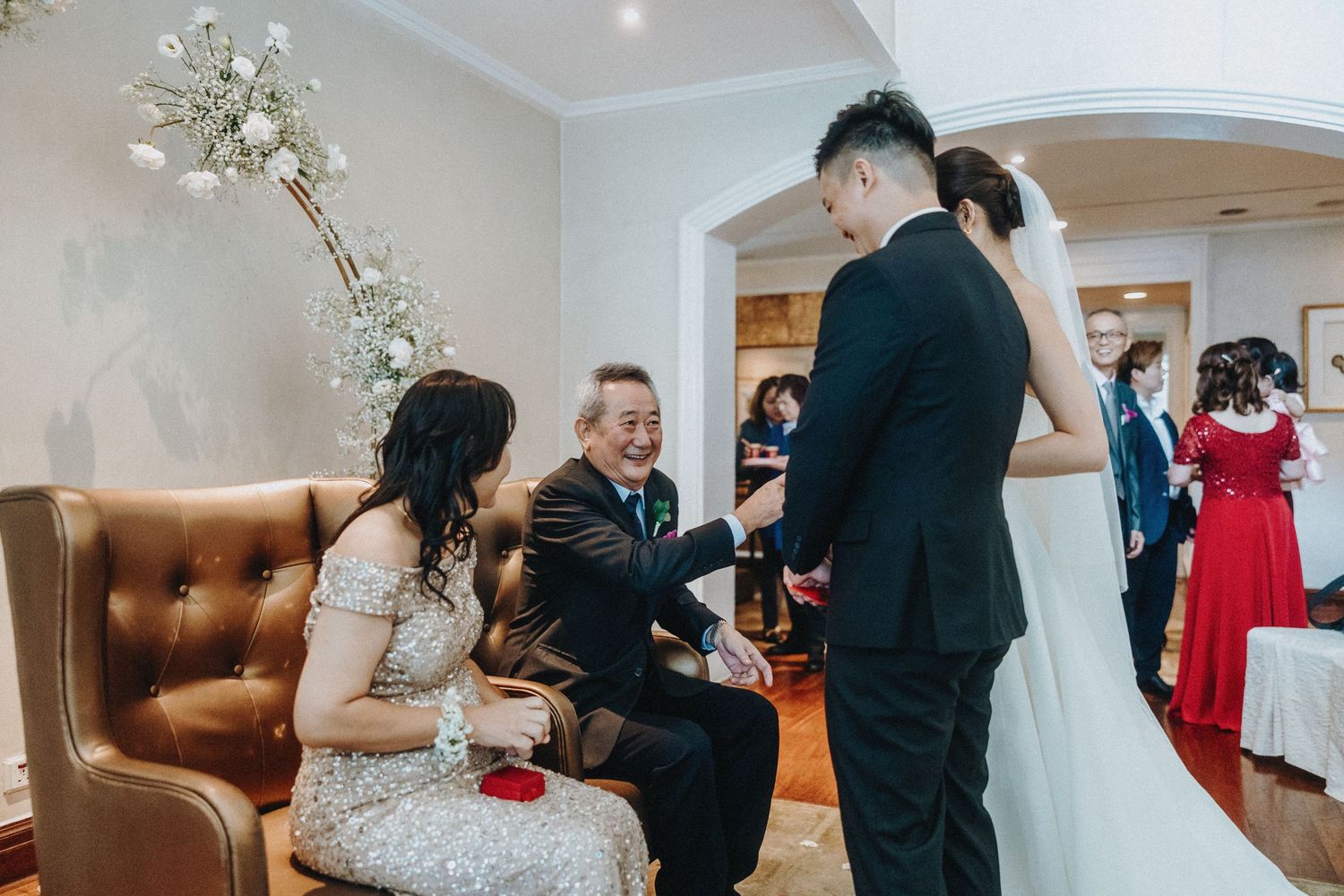 Wedding celebration scene with elegant decor and guests in formal attire.
