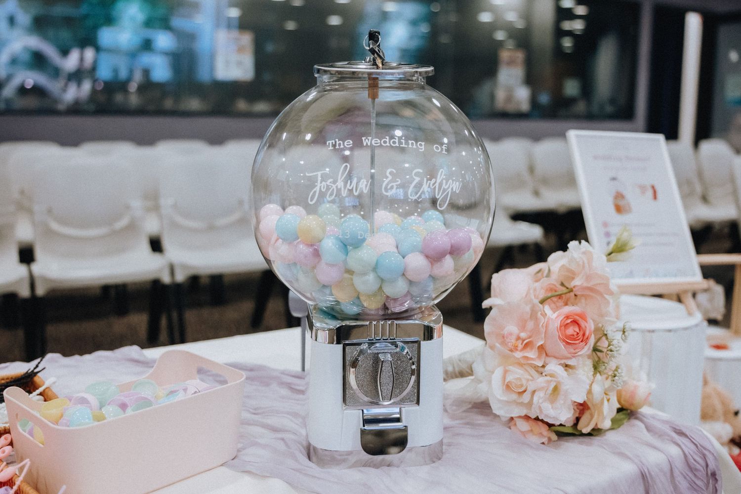Wedding reception table decorations featuring glass centerpieces with pastel flowers and candies.