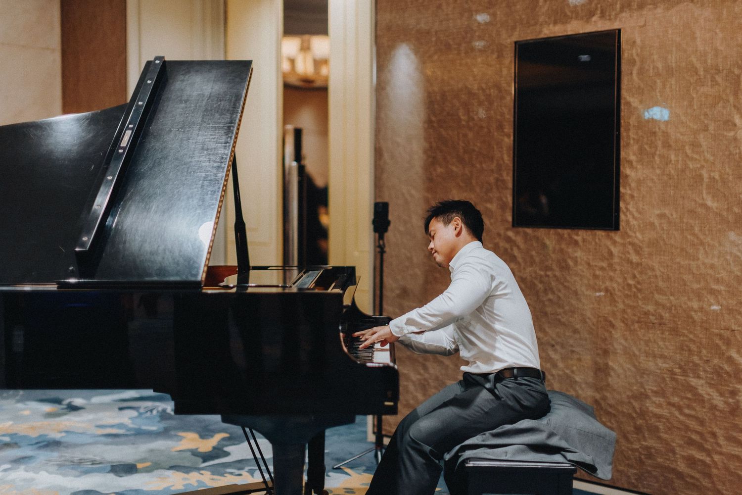 Wedding couple taking romantic photos near a grand piano.