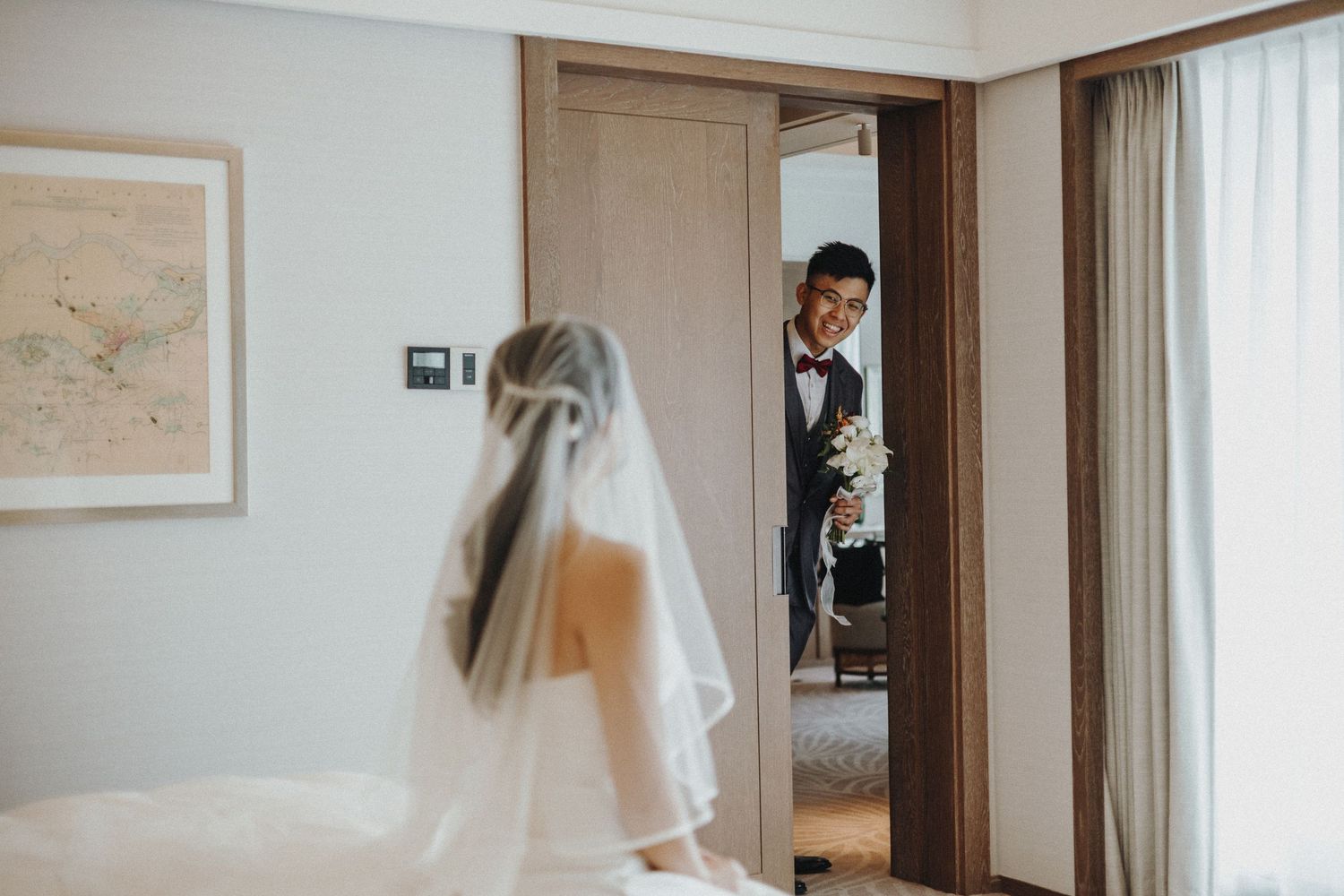 Wedding preparations in a modern hotel room with white decor and wooden accents.