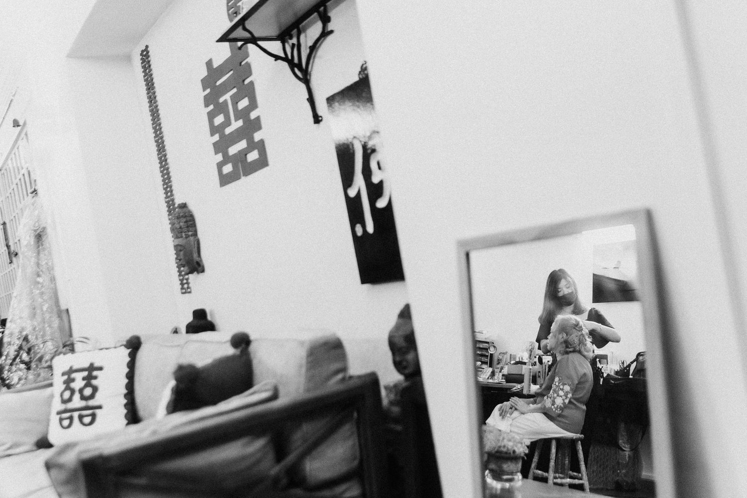 Black and white photographs displayed on a wall in a gallery or exhibition space creating an artistic arrangement.