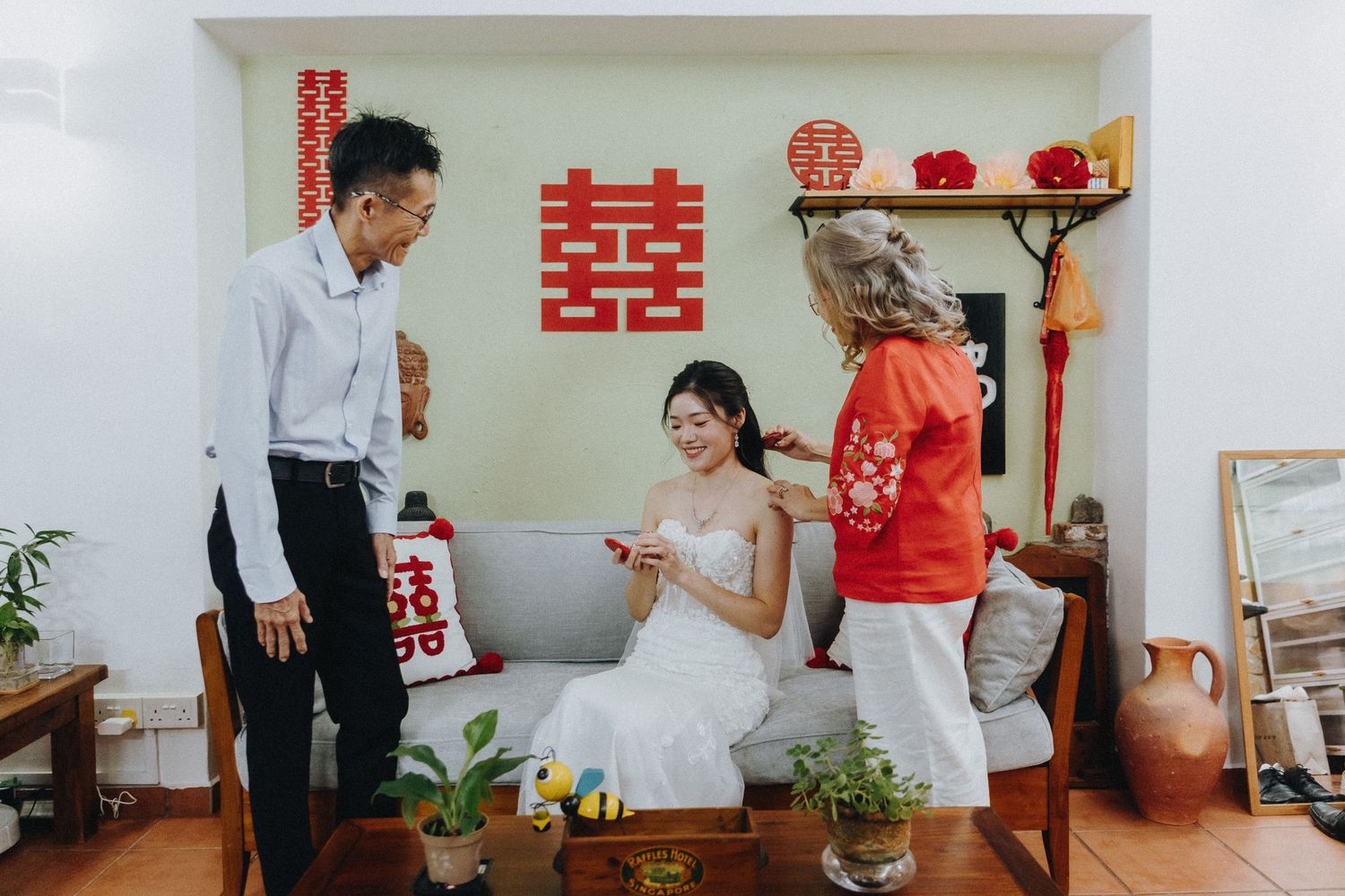 Tea ceremony setup with traditional Chinese decor and red double happiness symbols against white walls.