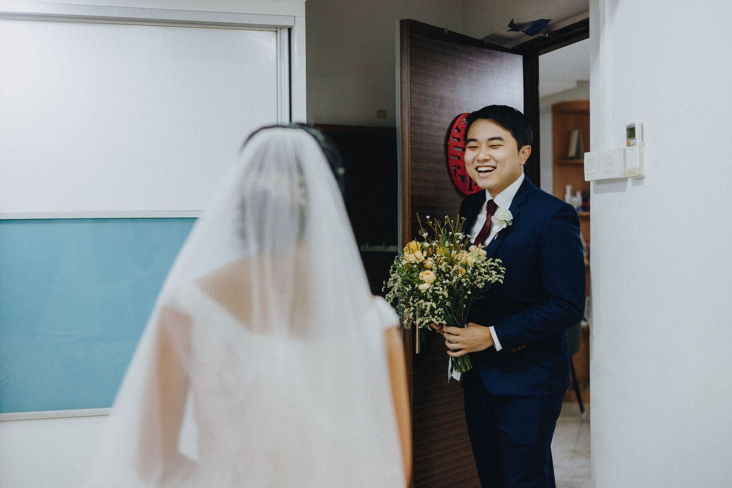 A bride and groom stand together during their wedding ceremony in a modern indoor venue.