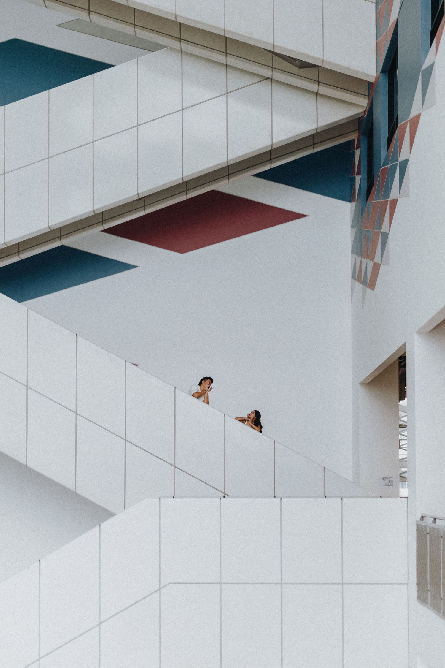 Architectural interior with dramatic angles and geometric shapes in white and teal.