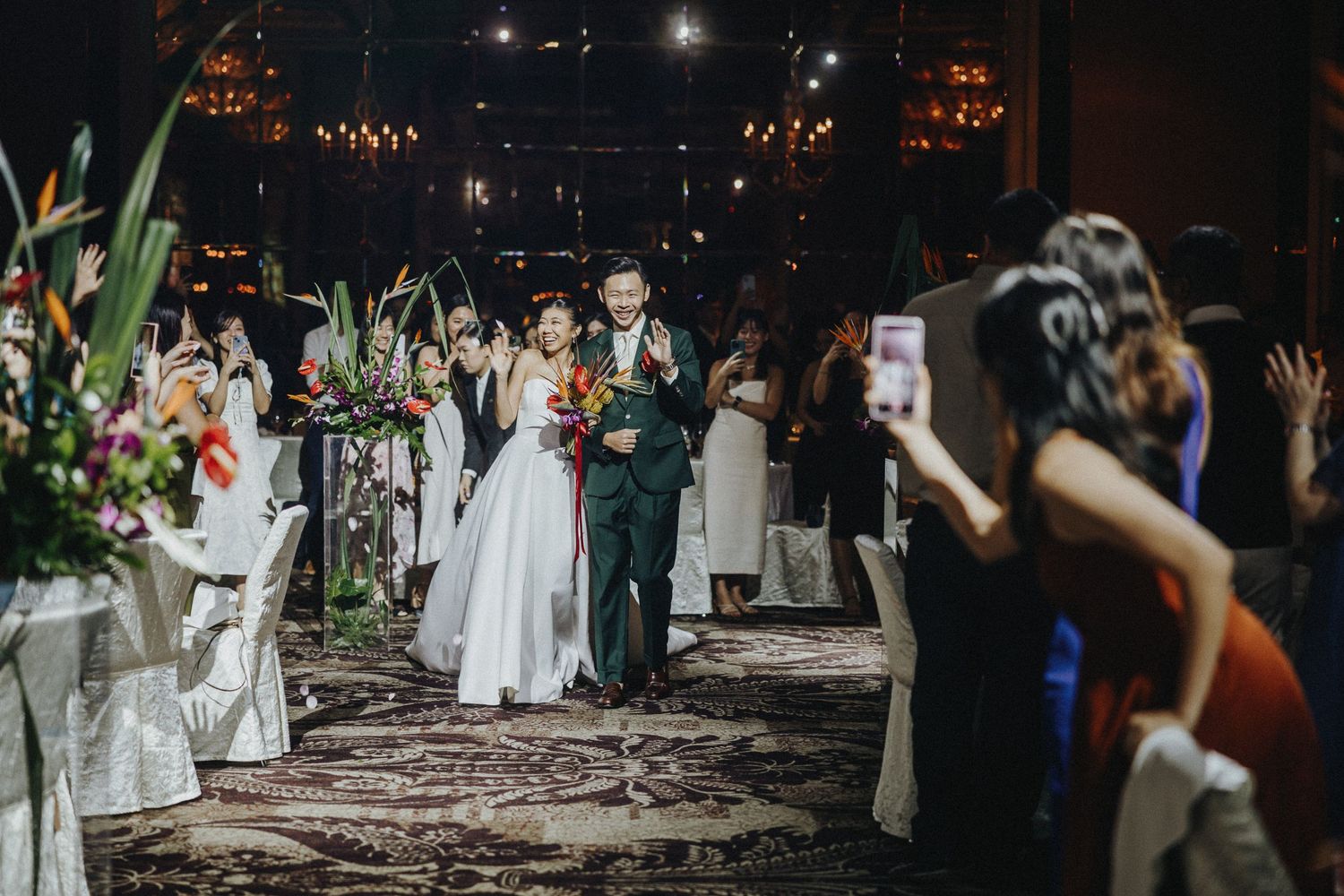 Wedding guests celebrate with sparklers at night creating magical light trails.