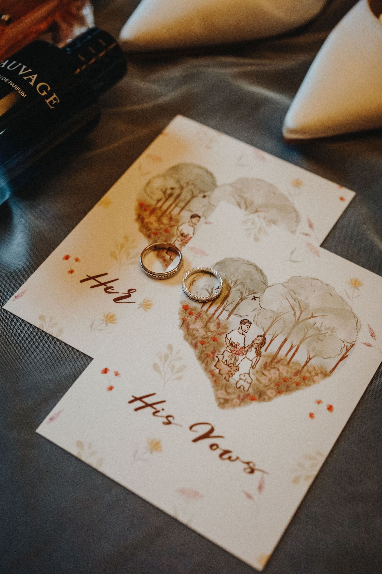 Romantic wedding stationery with gold foil details and heart designs on a dark wooden surface.