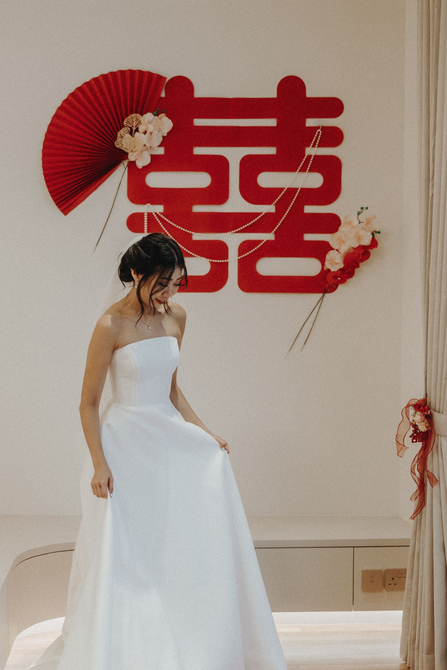 Chinese-style wedding setup with traditional red décor and white floral arrangements displayed in an elegant indoor venue.