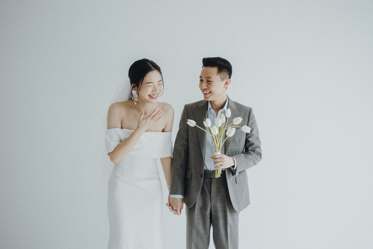 Black and white photograph mosaic showing various wedding poses and moments in a clean minimalist studio setting.