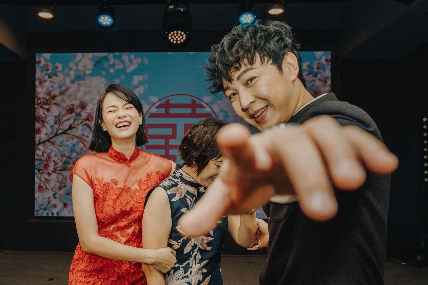 A joyful moment during a traditional Chinese wedding celebration with people in festive attire.
