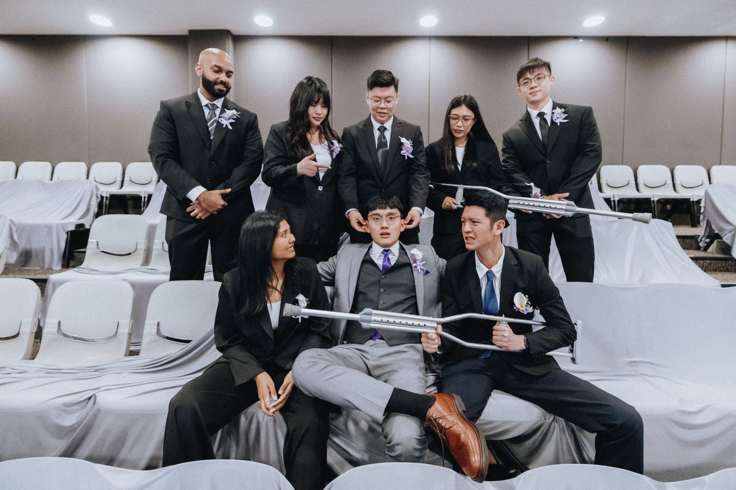 Group in formal business attire gathered in auditorium seating for a professional meeting.