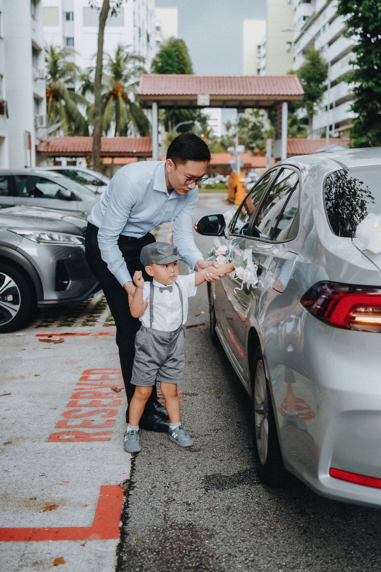 Person inspecting parked cars in a rainy parking lot with detailed attention.