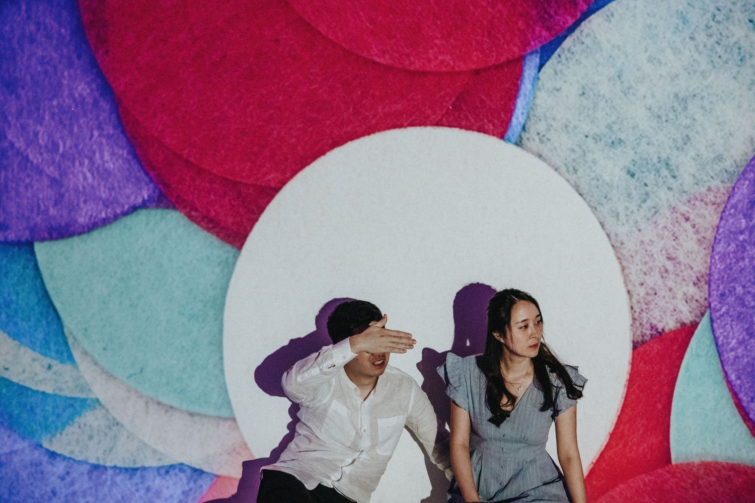 Contemporary portrait against colorful geometric backdrop with red and blue circles.