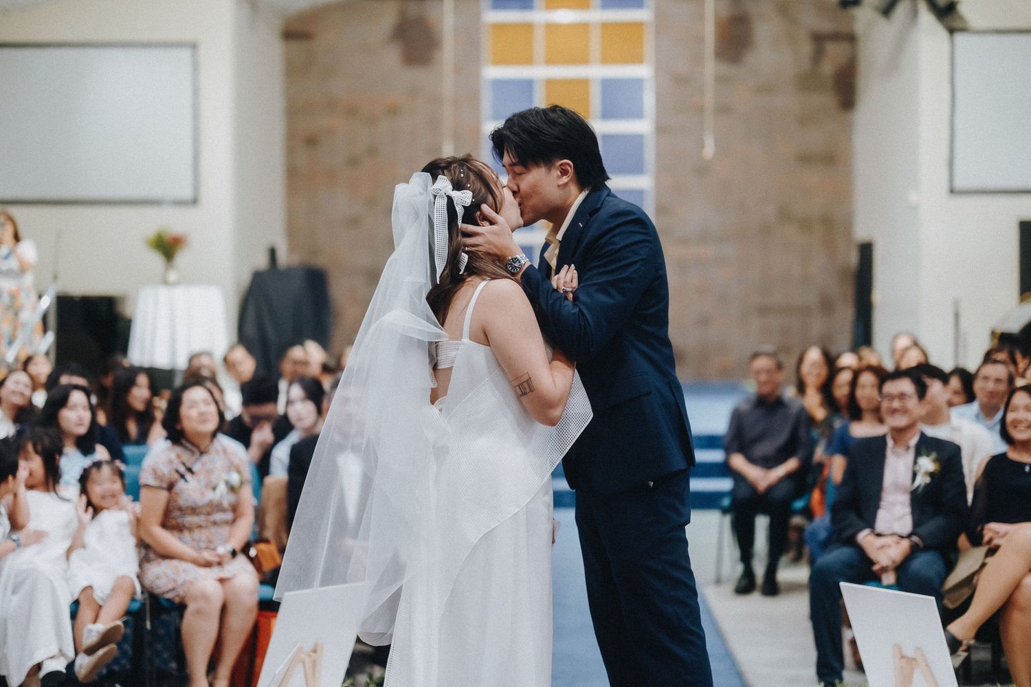 Wedding ceremony in a modern church with brick walls and geometric decor.