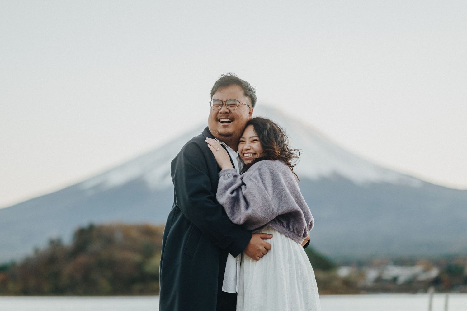 Couple embracing with Mount Fuji majestically rising in the background.