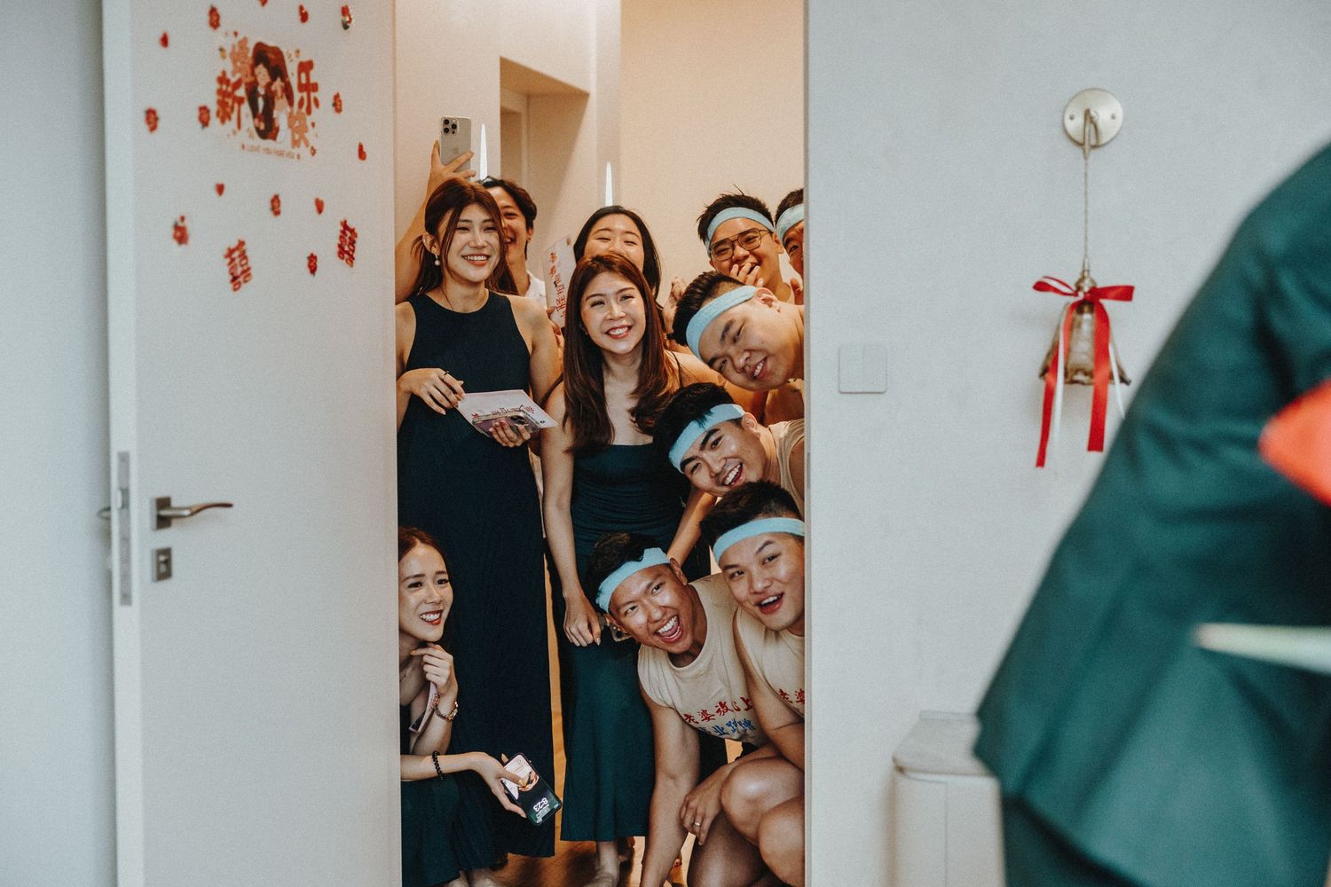 Group of guests excitedly peek through a doorway at a celebration event.