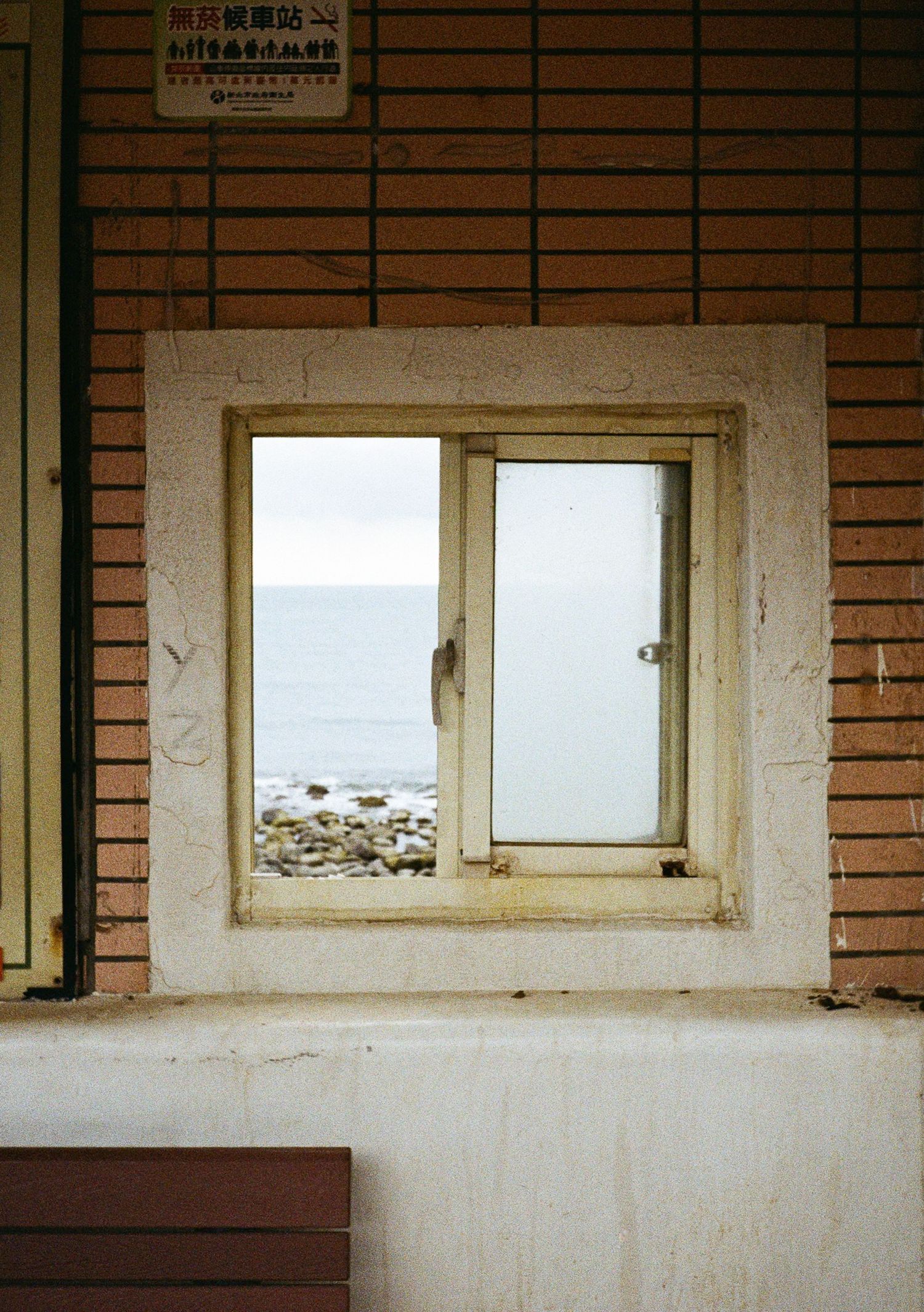 Minimalist architectural view of windows in a brick wall with white frames and empty interior.
