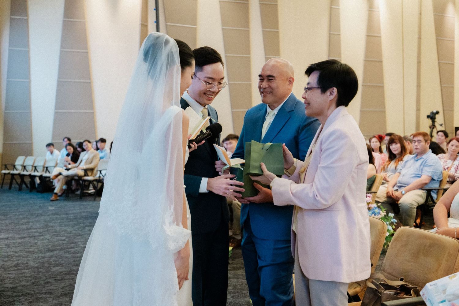 Bride and groom exchanging vows with officiant during intimate indoor wedding ceremony.