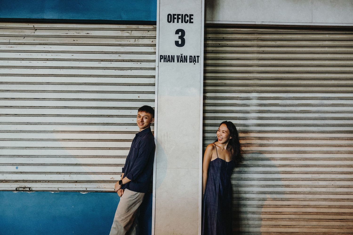 An industrial setting with metal garage doors and office signage creates an urban backdrop for photos.