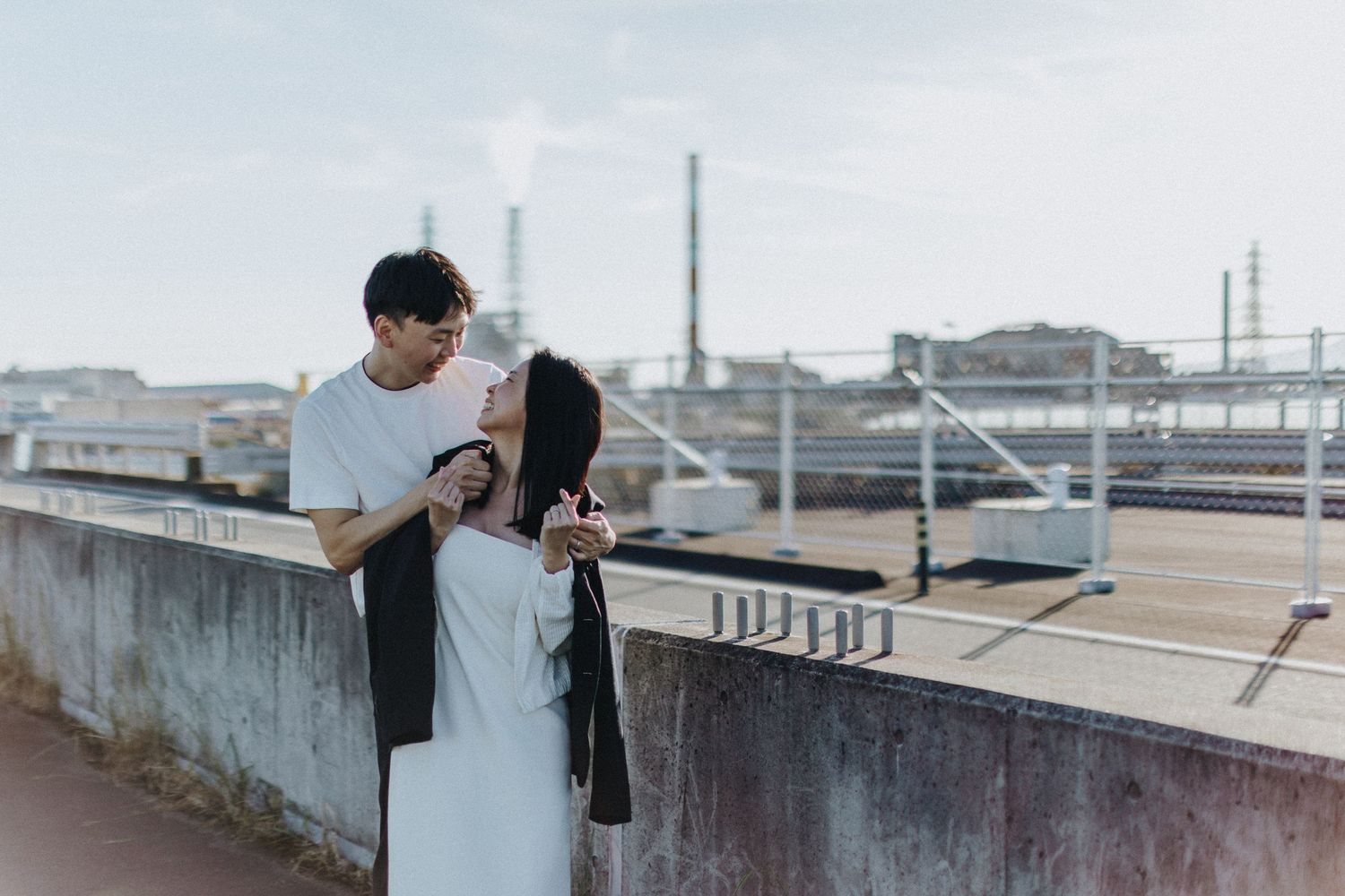 Urban rooftop scene with concrete walls and city buildings in the distance.