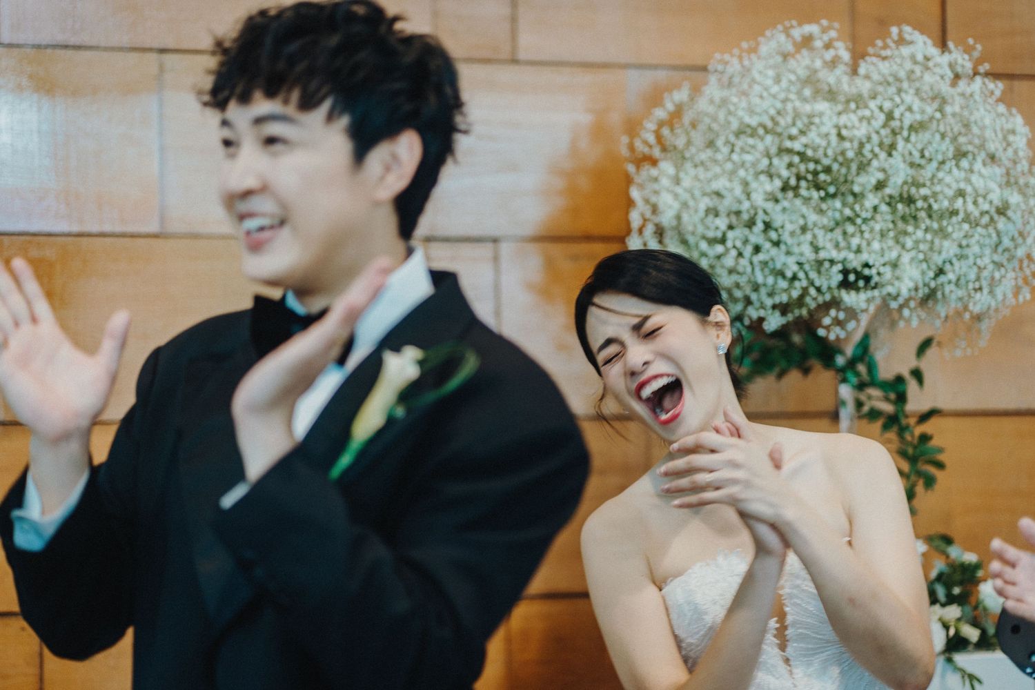 A candid wedding moment showing pure joy and laughter during the celebration.