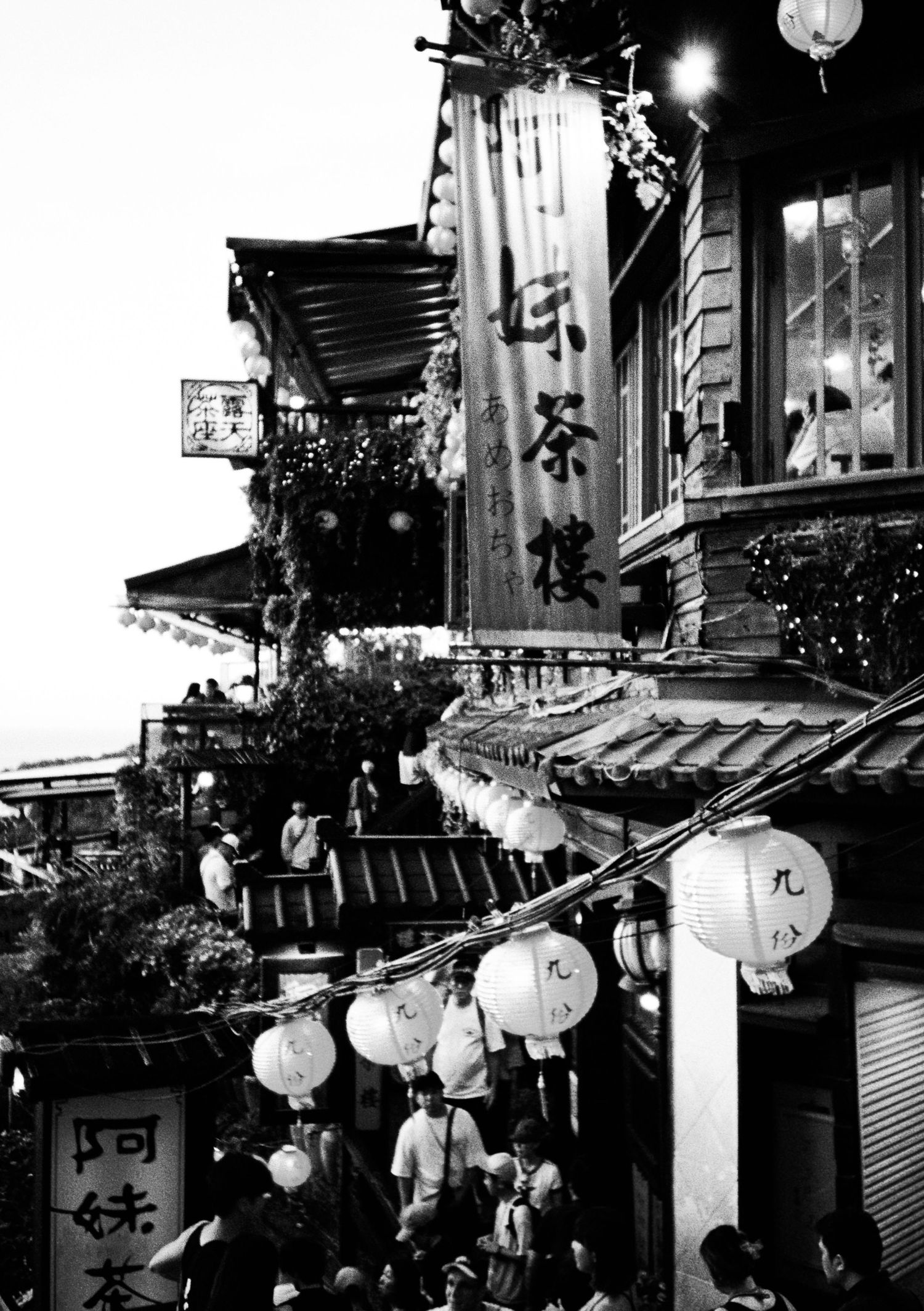 Traditional Japanese street with lanterns and architectural elements in black and white.