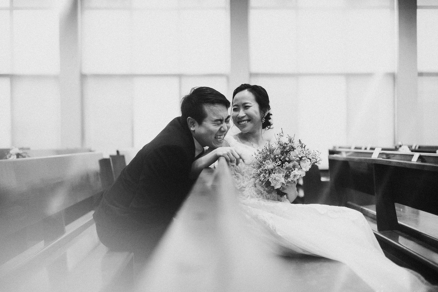 A joyful moment captured in black and white with laughter and a floral bouquet.