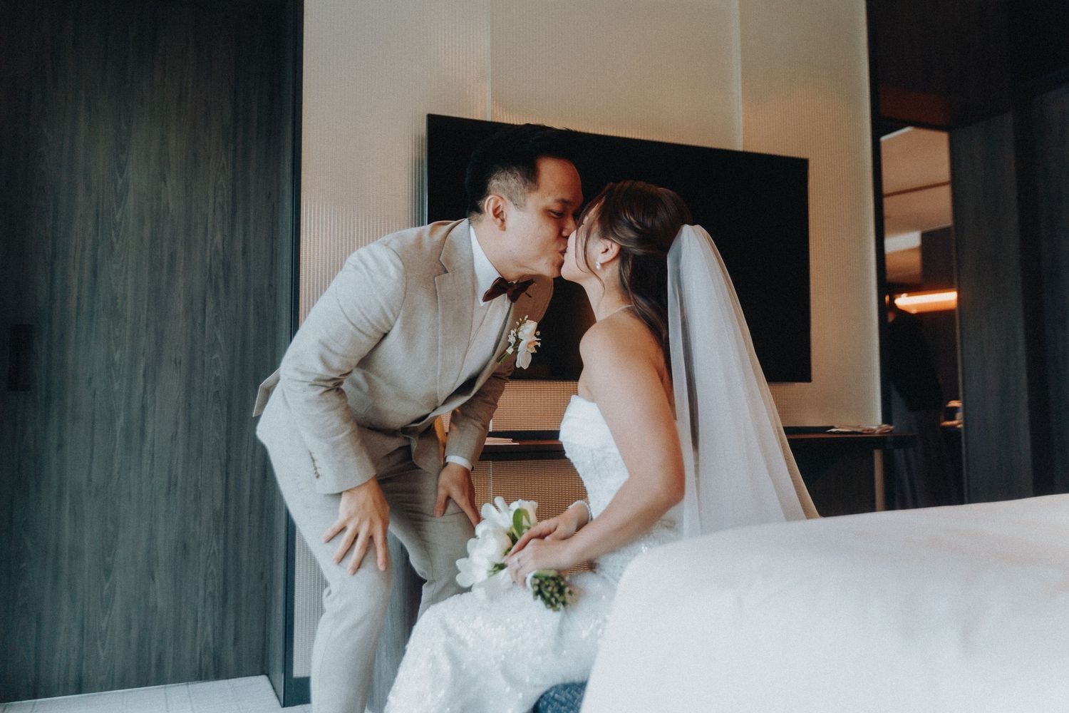 A romantic moment between newlyweds in a modern room with dark accent walls.