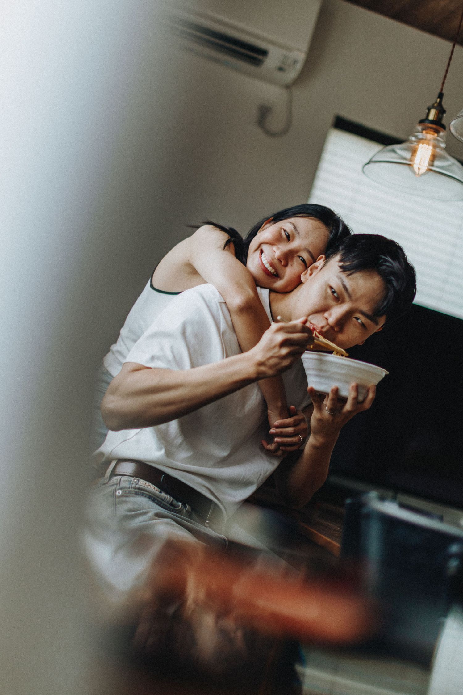 Intimate indoor portrait in soft natural lighting with white minimal decor.