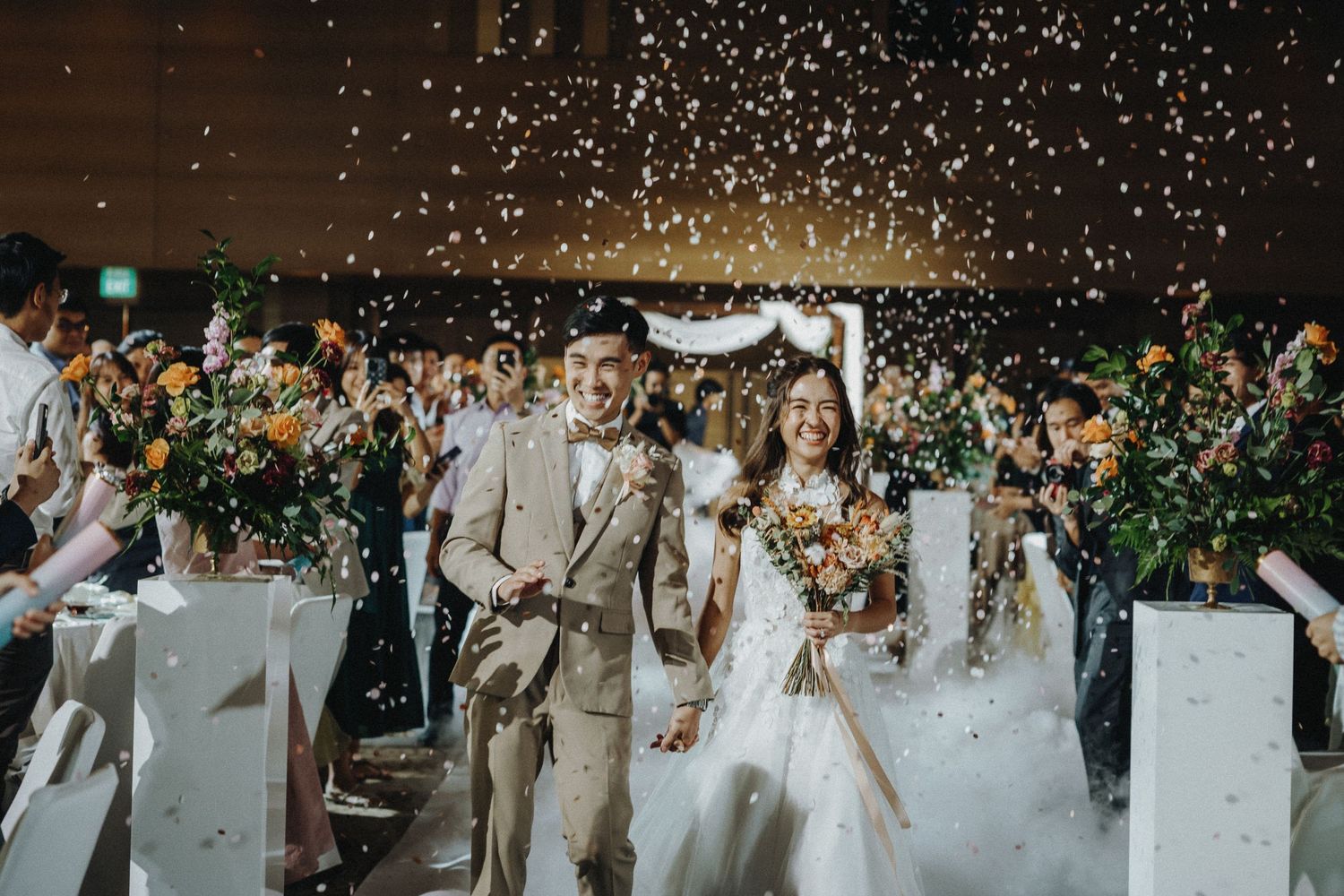 Wedding guests shower newlyweds with confetti during a joyful celebration outdoors.