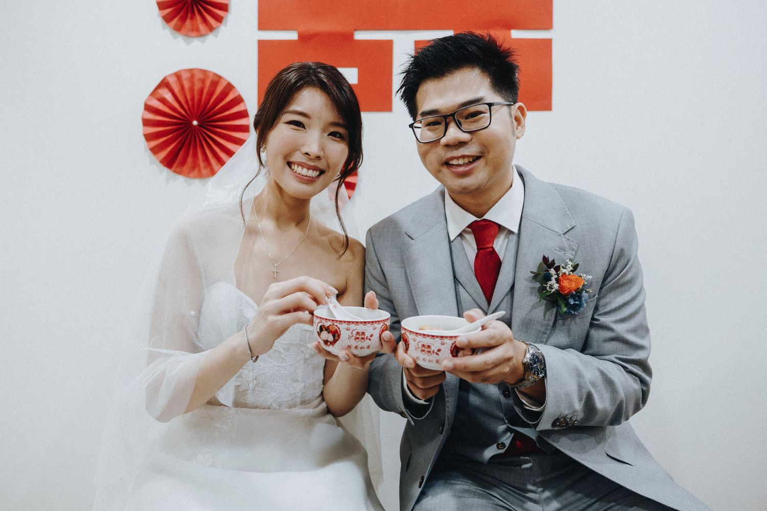 A couple shares tea and laughter during a traditional Chinese wedding tea ceremony.