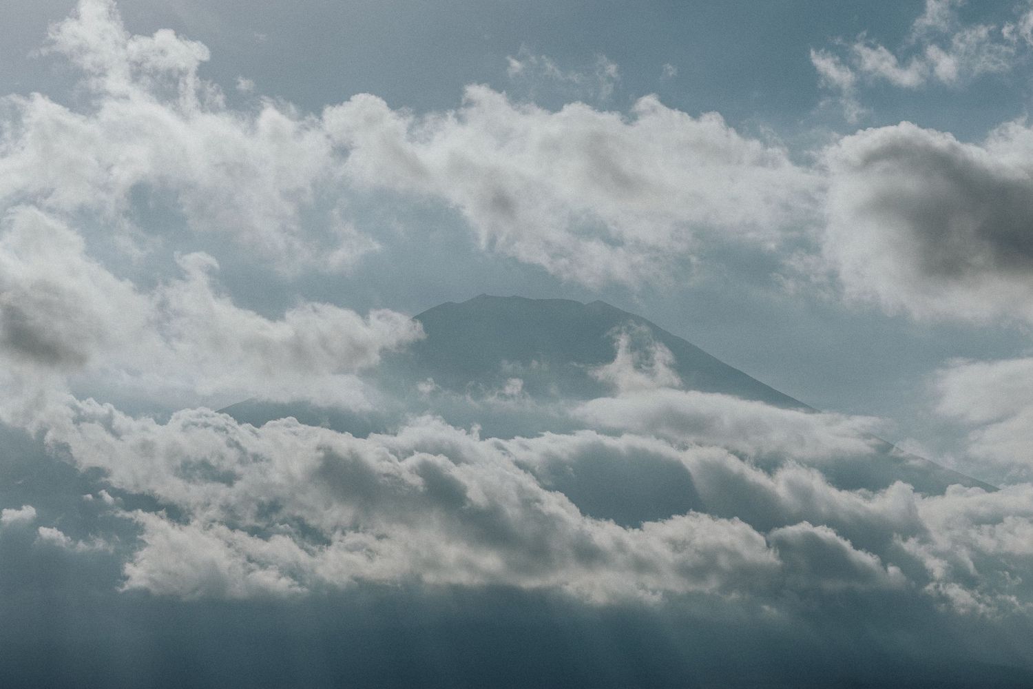 Dramatic sky with puffy white clouds against a moody blue backdrop stretches across the horizon.