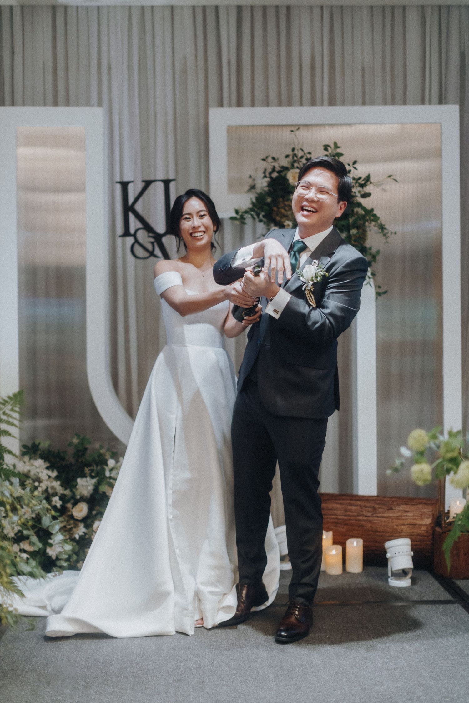 A wedding celebration with elegant white floral decorations and draped backdrop.