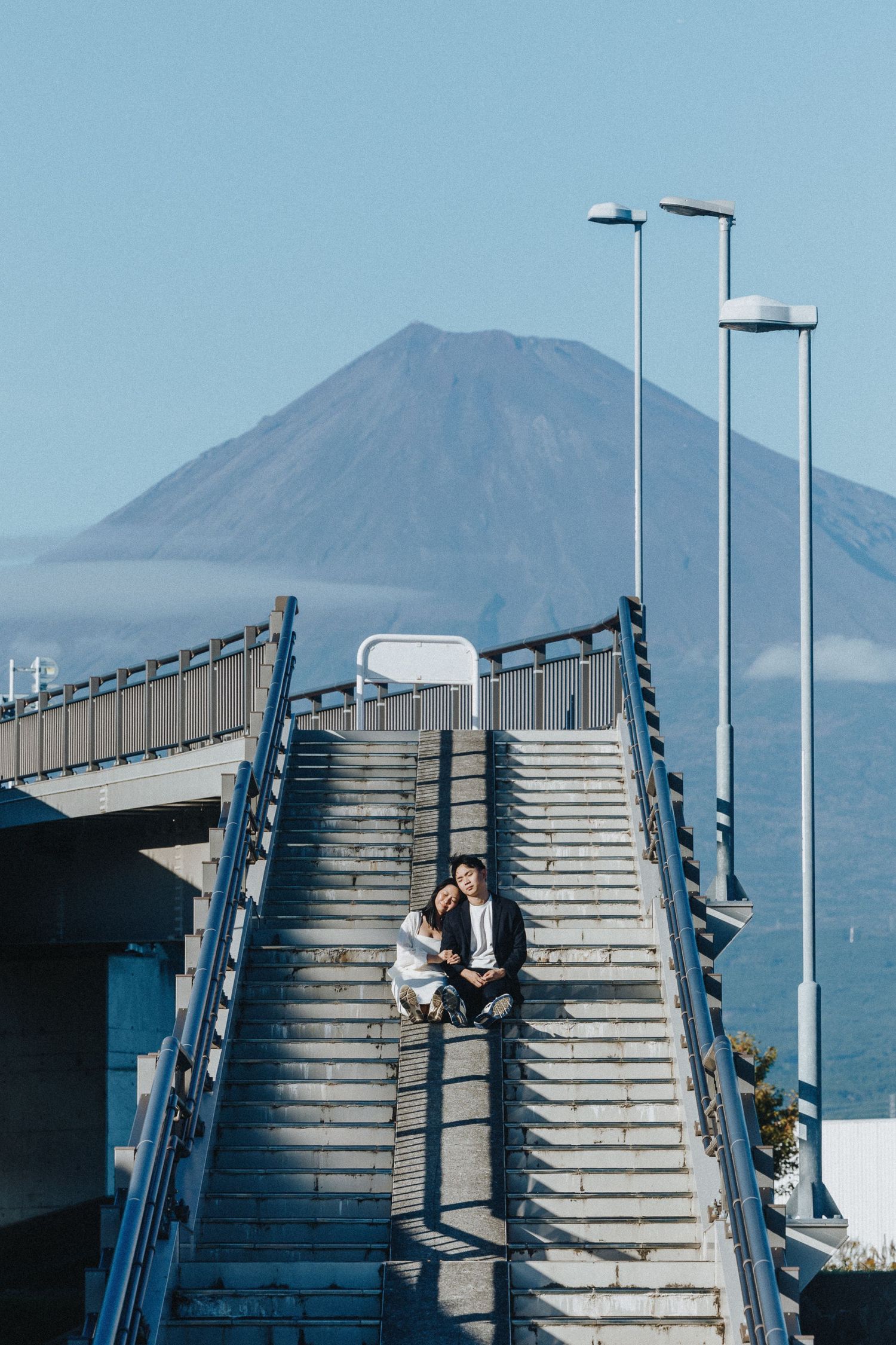A sequence of photos showing a figure ascending concrete stairs with a mountain landscape in the background.