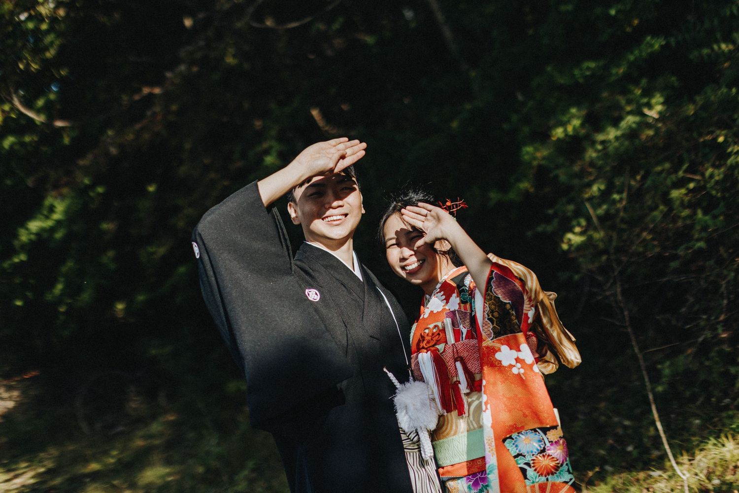 A group hosts an outdoor graduation party with balloons and presents on display in a sunny backyard setting.
