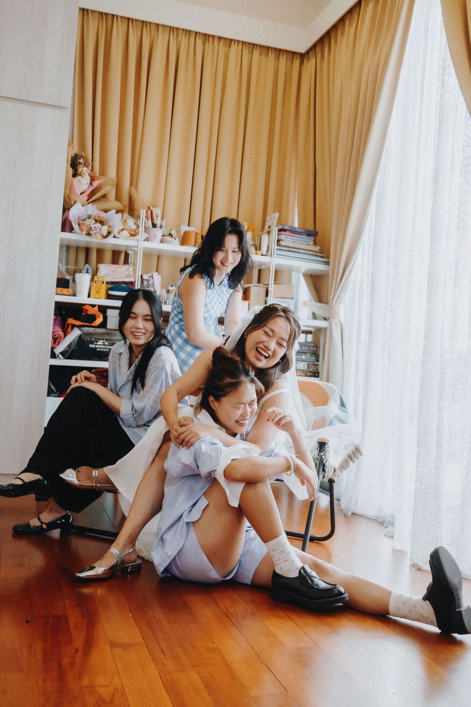 Fun candid photo shoot on wooden floor with playful poses.