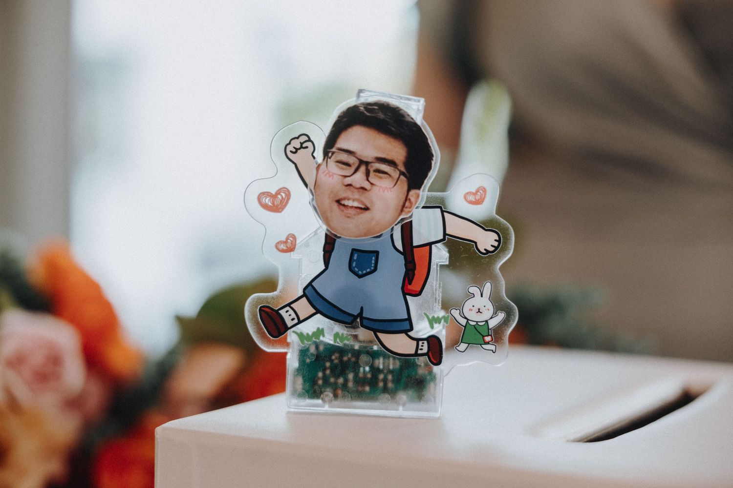 A custom cartoon illustration of a backpack-wearing character displayed as a wedding decoration.